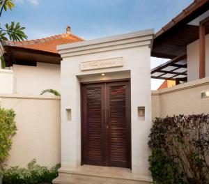 una casa con una porta marrone davanti di Villa Apanya Sanur a Sanur