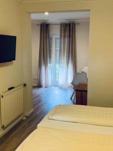 a room with two beds and a television in a room at Landhotel Franck Garni in Brietlingen