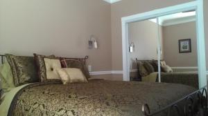 a bedroom with a large bed and a mirror at Villa with Waterfront Deck 23 Mi to Bourbon Street! in Venetian Isles