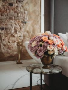 un jarrón lleno de flores sentado en una mesa en Hotel Pacai, Vilnius, a Member of Design Hotels en Vilna