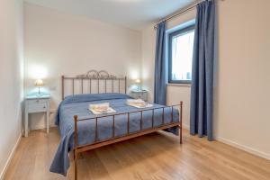 ein Schlafzimmer mit einem Bett und einem großen Fenster in der Unterkunft Agriturismo La Semente in Spello