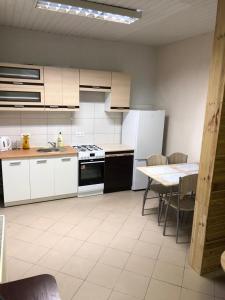 a kitchen with white appliances and a table with chairs at Apartament dla 4 osób in Dęblin