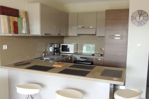 Una cocina con encimera con fregadero y microondas. en Appartement vue piscine dans résidence de standing, en Porto Vecchio