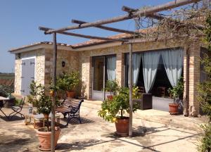 a brick house with a patio with potted plants at Villa Soleanda in Marsiliana