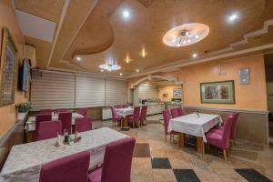 a dining room with tables and purple chairs at Hotel Park in Srebrenik