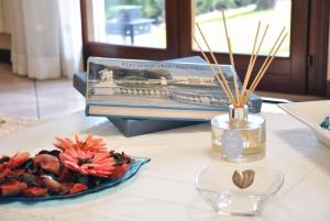 a table with a book and a plate of flowers at Villa Stefania in Noventa Padovana