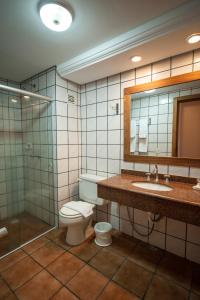 a bathroom with a toilet and a sink and a shower at Farina Park Hotel in Bento Gonçalves