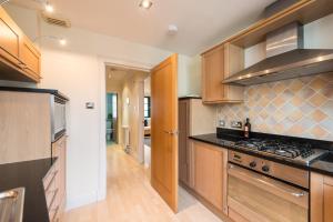 a kitchen with wooden cabinets and a stove top oven at 3c Dublin Street in Edinburgh