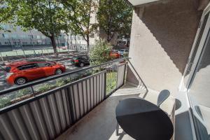 a balcony with a red car parked on a street at Forenom Serviced Apartments Helsinki Lapinlahdenkatu in Helsinki