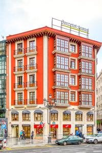 un edificio naranja en la esquina de una calle en Sercotel Arenal Bilbao en Bilbao