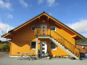 a yellow house with a deck and some chairs at Wacholder in Rieden