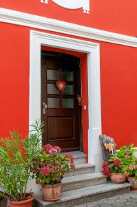 un corazón colgando de la puerta de una casa roja en Hotel Schuberths am Markt, en Buttenheim