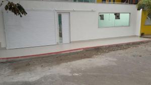 Casa com Piscina e Churrasqueira e excelente Localização em Piuma في بيوما: مبنى أبيض مع نافذة على جانبه