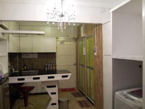 a kitchen with a counter and a chandelier at Fastbook Bendera Home 8 & 10pax in Ayer Itam +46 photos