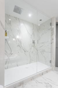 a bathroom with a shower with white marble walls at The Scotsman Hotel in Edinburgh