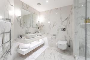 a white bathroom with a sink and a toilet at The Scotsman Hotel in Edinburgh