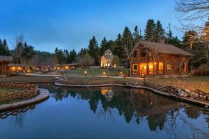 a log house with a pond in front of it at All Seasons Paradise in Khrisovítsion