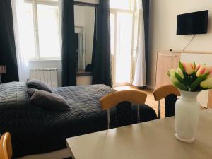 Un dormitorio con una cama y una mesa con un jarrón de flores en Modern cozy apartment in central Prague, en Praga