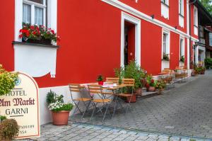 a red building with a table and chairs on a street at Hotel Schuberths am Markt in Buttenheim