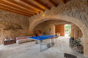 una mesa de ping pong en una habitación con una pared de piedra en Son Servera - 306693, en Son Servera