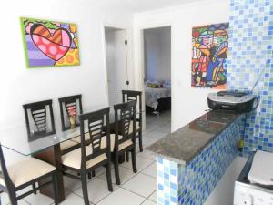 a kitchen with a table and chairs and a painting at Apartamento Residence Praia Porto Iracema in Fortaleza