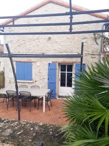 un patio avec des tables et des chaises en face d'un bâtiment dans l'établissement Proche Futuroscope - Maison de campagne - La petite Lucie, à Savigny-sous-Faye