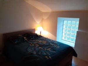 - une chambre avec un lit, une lampe et une fenêtre dans l'établissement Proche Futuroscope - Maison de campagne - La petite Lucie, à Savigny-sous-Faye