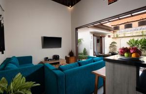 un soggiorno con divani blu e TV di Villa Apanya Sanur a Sanur