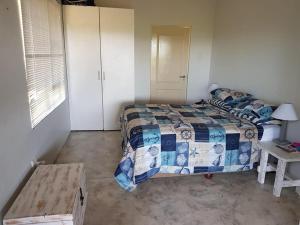 um quarto com uma cama e uma mesa em Nkumbe 7C em Ponta Malangane