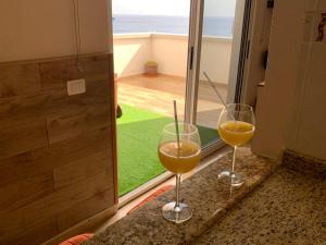 twee wijnglazen op een aanrecht voor een raam bij PLAYA CHICA BEACH 1 in Santa Cruz de Tenerife