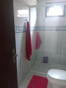 a bathroom with a shower and a toilet at Um quarto em casa agradável in Perequê