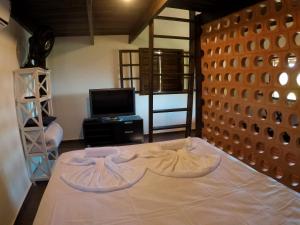uma sala de estar com uma cama e uma televisão em Chalés da Longa em Angra dos Reis