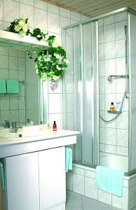 a bathroom with a sink and a shower at Hotel Garni Hubertushof in Bad Füssing