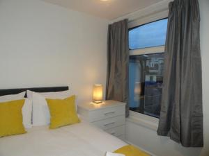 1 dormitorio con 1 cama con ventana y lámpara en Luckwell Too by Cliftonvalley Apartments en Bristol