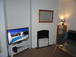 ein Wohnzimmer mit einem TV und einem Kamin in der Unterkunft Luckwell Too by Cliftonvalley Apartments in Bristol