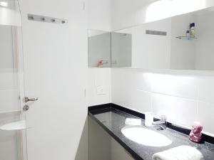 Baño blanco con lavabo y espejo en pisos baires 6 - Great and lovely, in the heart of Baires City! en Buenos Aires