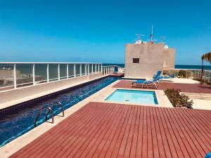 a swimming pool on the roof of a building at Apartamento Beira Mar Maceió in Maceió