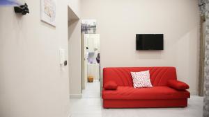 - un canapé rouge dans le salon doté d'une télévision dans l'établissement Spicoli 86, à Naples