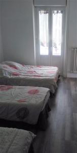 a group of three beds in a room at Doux Ombrages in La Bourboule