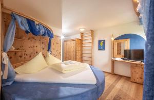 1 dormitorio con 1 cama con dosel azul en Bed & Breakfast Landhaus Strasser, en Söll