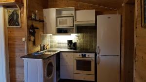 een keuken met een witte koelkast en een fornuis bij Leilighet 2240 in Haugsvær