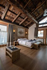 een grote kamer met 2 bedden en een tafel bij La Grolla Rooms & Apartments in Livigno