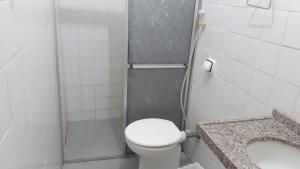 a small bathroom with a toilet and a sink at Pousada Mundaú in Mundaú
