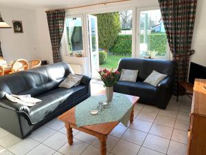a living room with a black leather couch and a table at Vakantiewoning Kortgene in Kortgene