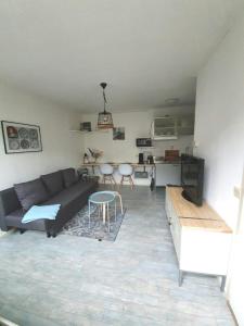 ein Wohnzimmer mit einem Sofa und einem Tisch in der Unterkunft Tuinhuis in Schagen