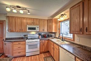 a kitchen with wooden cabinets and white appliances at Quaint Duluth Hideaway with Private Fenced-In Yard! in Duluth