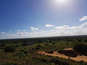 uma vista aérea de um campo com uma casa à distância em Nkumbe 7C em Ponta Malangane