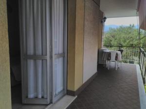 balkon ze stołem i szklanymi drzwiami w obiekcie Valter Apartment w mieście Pietra Ligure