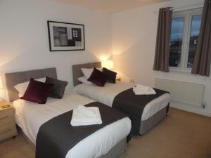a hotel room with two beds and a window at Redmarley House by Cliftonvalley Apartments in Cheltenham