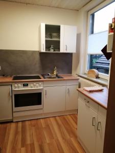 a kitchen with white cabinets and a stove top oven at Gästehaus Wetzel in Braunlage